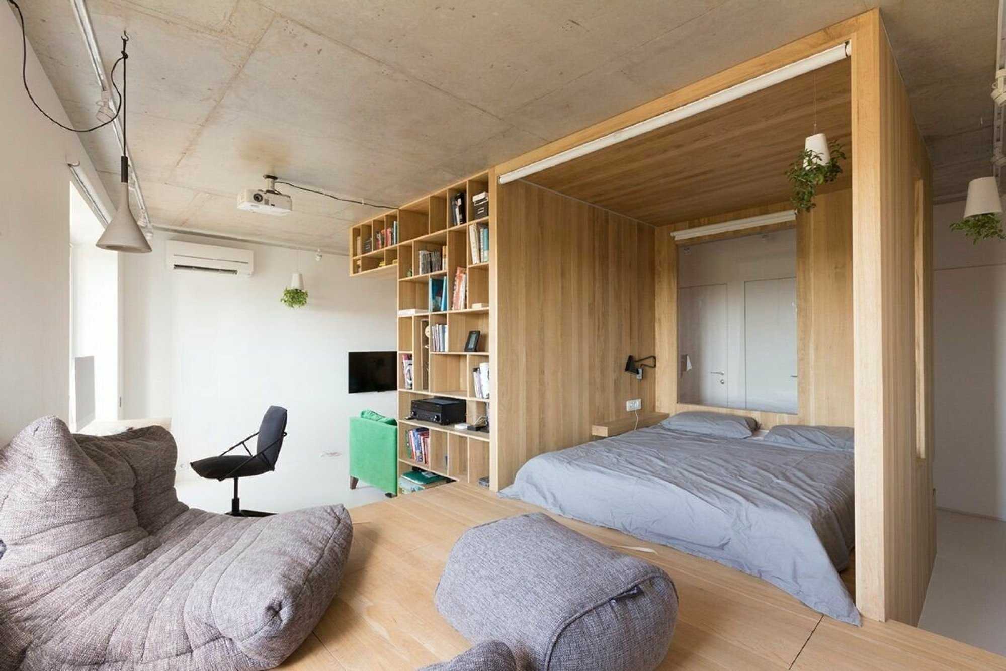 Кровать в однушке. Кровать за перегородкой. Спальное место в маленькой квартире. Спальня с высокими потолками. Кровать на подиуме в интерьере.